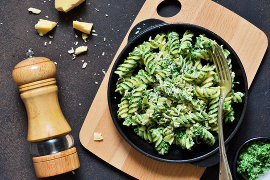 Pasta with pesto sauce is a traditional Italian dish. Rotini. Food background. View from above.