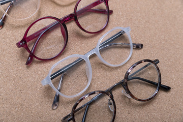 Different eyeglass frames on cork board