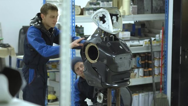 A group of engineers creates a modern robot or android. Check and repair broken items. Manufacture and manufacture of robots