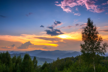 Fototapeta na wymiar Multicolor Sunset Sky in Forested Mountains