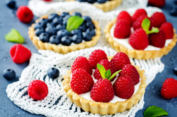 Raspberry and blueberry tartlets with fresh berries and mint leaves