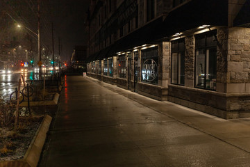 Fototapeta na wymiar Toronto, CANADA - December 4th, 2019: Dramatic rainy night with empty streets and reflecting traffic lights in city suburbia roads