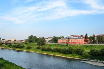 View of the San River. Przemysl - Polish city on the border with Ukraine. Peyziz. A traveler will fall in love with this river, greenery along the banks, a beautiful building on the right. Blue sky wi
