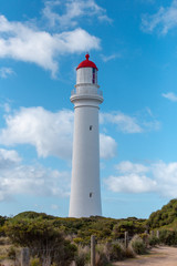 Fototapeta na wymiar White and red lighthouse in blue sky