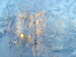 Ice pattern and sunlight on winter glass