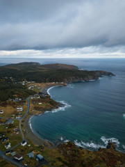 Obraz premium Aerial view of a small town on a rocky Atlantic Ocean Coast during a cloudy day. Taken in Paradise, Twillingate, Newfoundland, Canada.