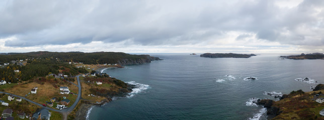 Aerial view of a small town on a rocky Atlantic Ocean Coast during a cloudy day. Taken in Paradise, Twillingate, Newfoundland, Canada.