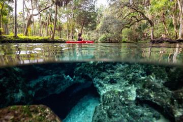 Over and Under picture of a girl kayaking in a lake near an underwater cave formation. Taken in 7...