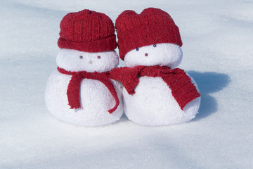 Two lovely snowmen toys on the white snow, holiday celebration concept