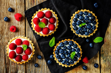 Raspberry and blueberry tartlets with fresh berries and mint leaves