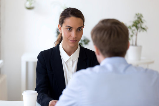 Confident female hr manager, employer holding interview with job applicant, employment, hiring, serious focused woman looking at man, interested to candidate, business partners negotiations
