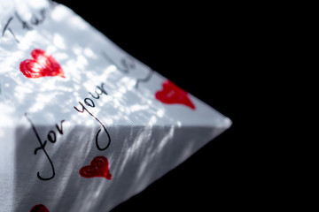 On a black background is a white note with red hearts on which the words of gratitude are written.