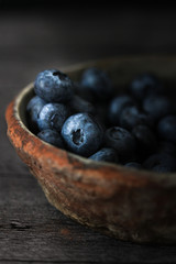 Blueberry on white wooden table Blueberries in wooden vintage bowl, Close up of blue berry