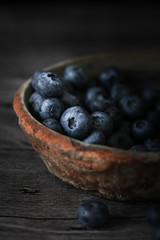 Blueberry on white wooden table Blueberries in wooden vintage bowl, Close up of blue berry