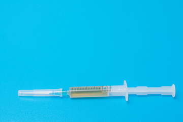 small drug syringe on a blue background