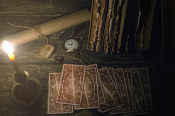Tarot cards on fortune teller table in the lights of burning candle background. Futune reading...