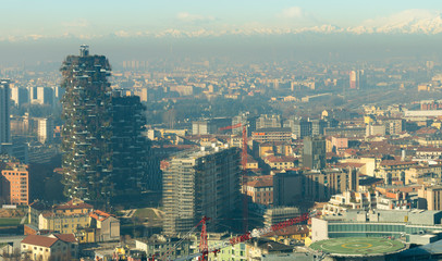 Milan skyline, aerial view of Bosco Verticale (Vertical forest) skyscrapers and the city covered by smog. Italian landscape.