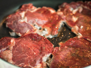 red beef steak being cooked in pan close-up view
