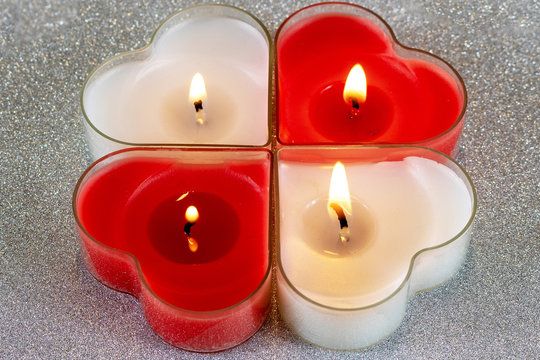Heart shaped candle burning red and White