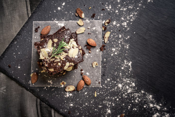 Chocolate brownie cake, dessert with nuts on dark background. copy space 