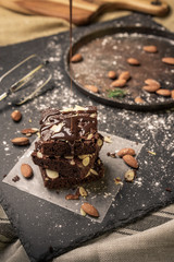 A stack of chocolate brownies on dark plat background ,homemade bakery and dessert.