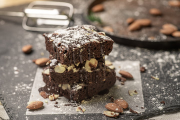 A stack of chocolate brownies on dark plat background ,homemade bakery and dessert.