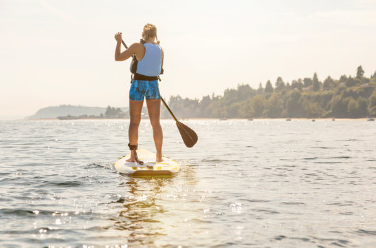 Strong, Healthy Woman Paddleboarding. Women's Outdoor Adventure Summer Water Sports.