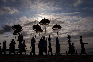 Balinese people celebrate their ceremony during the day time at the beach.