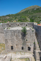 Medieval stone fortress is located high in the mountains.