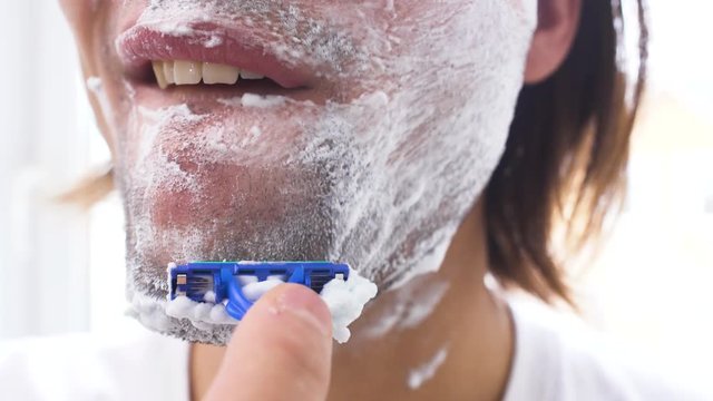 Man shaving with foam and manual razer