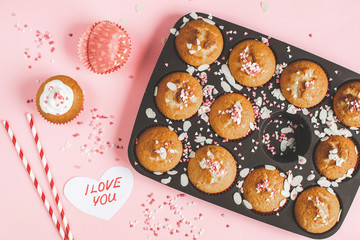 Muffins with sweet heart decor, pink background, paper heart with text I love you, Valentine's day