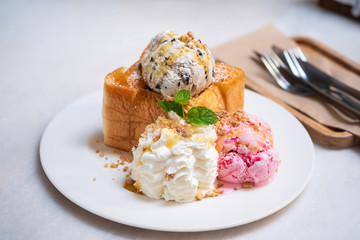 Bread Honey toast topping by almond slice with whipping cream and  ice cream, High-calorie food, clipping path.