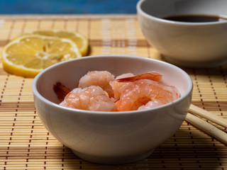 Shrimps with lemon and soy sauce, wooden sticks. Seafood.