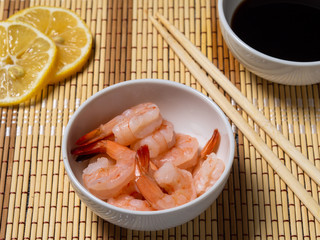 Shrimps with lemon and soy sauce, wooden sticks. Seafood.