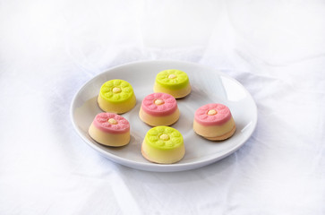 White chocolate candies on a white plate. Confectionery on a white background.
