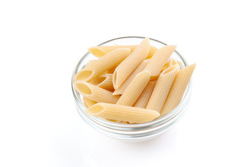 Raw feathers macaroni in bowl. Italian pasta close up, isolated on the white background