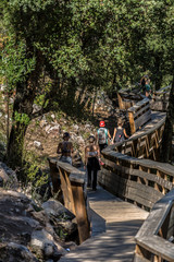 Fototapeta na wymiar View of people walking on wooden suspended pedestrian walkway, overlooking the Paiva river
