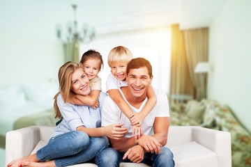 Beautiful smiling family sitting at sofa at home