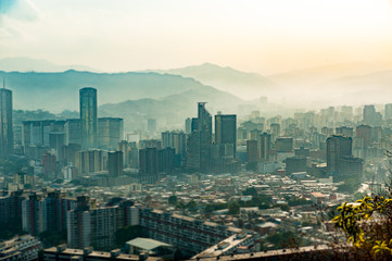 tilt shift landscape of caracas during hazy, dark moody day with pollution, at sunset