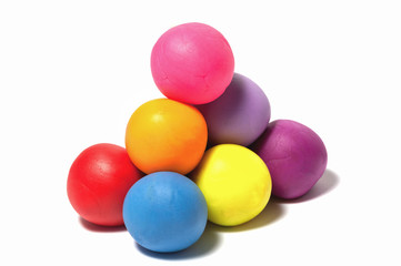 a pyramid of clay balls on white background