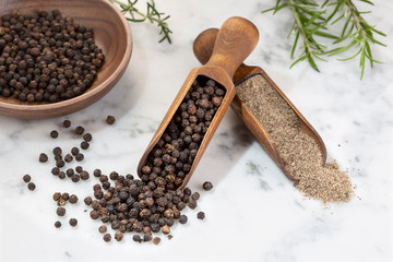 Black pepper seeds and Black pepper ground on marble background. Spices for cooking. Piper nigrum