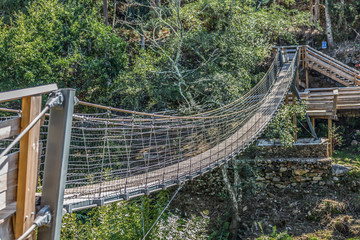 Obraz premium Suspension bridge view on pedestrian walkway on mountains