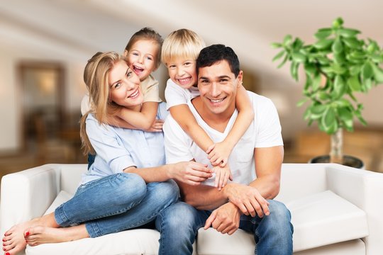 Young  family at home smiling at camera