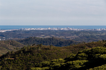 Obraz premium Beautiful nature landscape (panorama) and cityscape in Alentejo, Portugal. Beautiful hills and ocean in the far background.