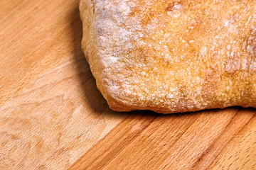 traditional italian wheat bread ciabatta with crispy crust on a wooden table