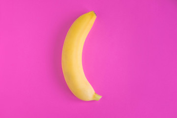 Conceptual photo of a banana on a pink background. Banana photo for advertising. Flat lay, top view.