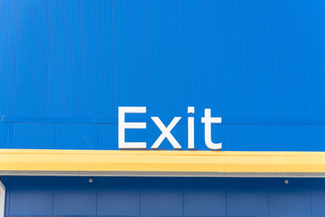 Close-up of outdoor exit sign on building facade