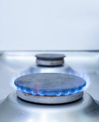 closeup of one stove gas burner with blue flame