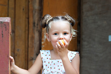 Peach mood! Girls have fun and eat peaches on the porch of a house in the woods.