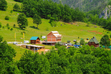 Montenegro mountains. A small village on the slope among the high mountains covered with green forest in the valley of the river Tara, Montenegro.